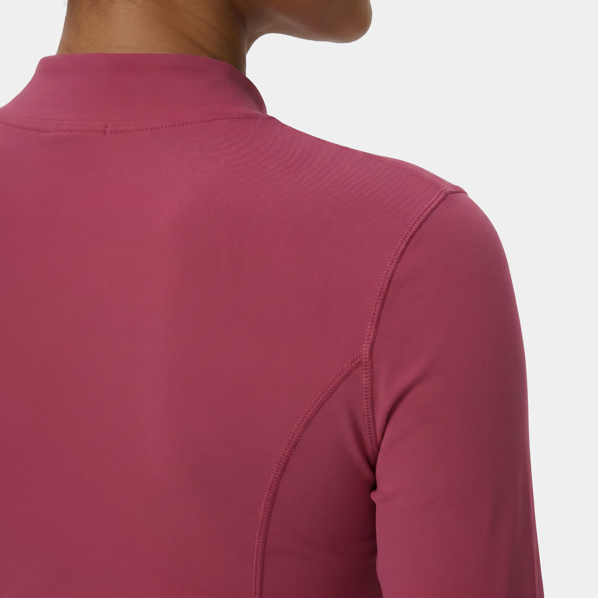 Close-up of a person wearing a pink long-sleeve athletic top on a white background